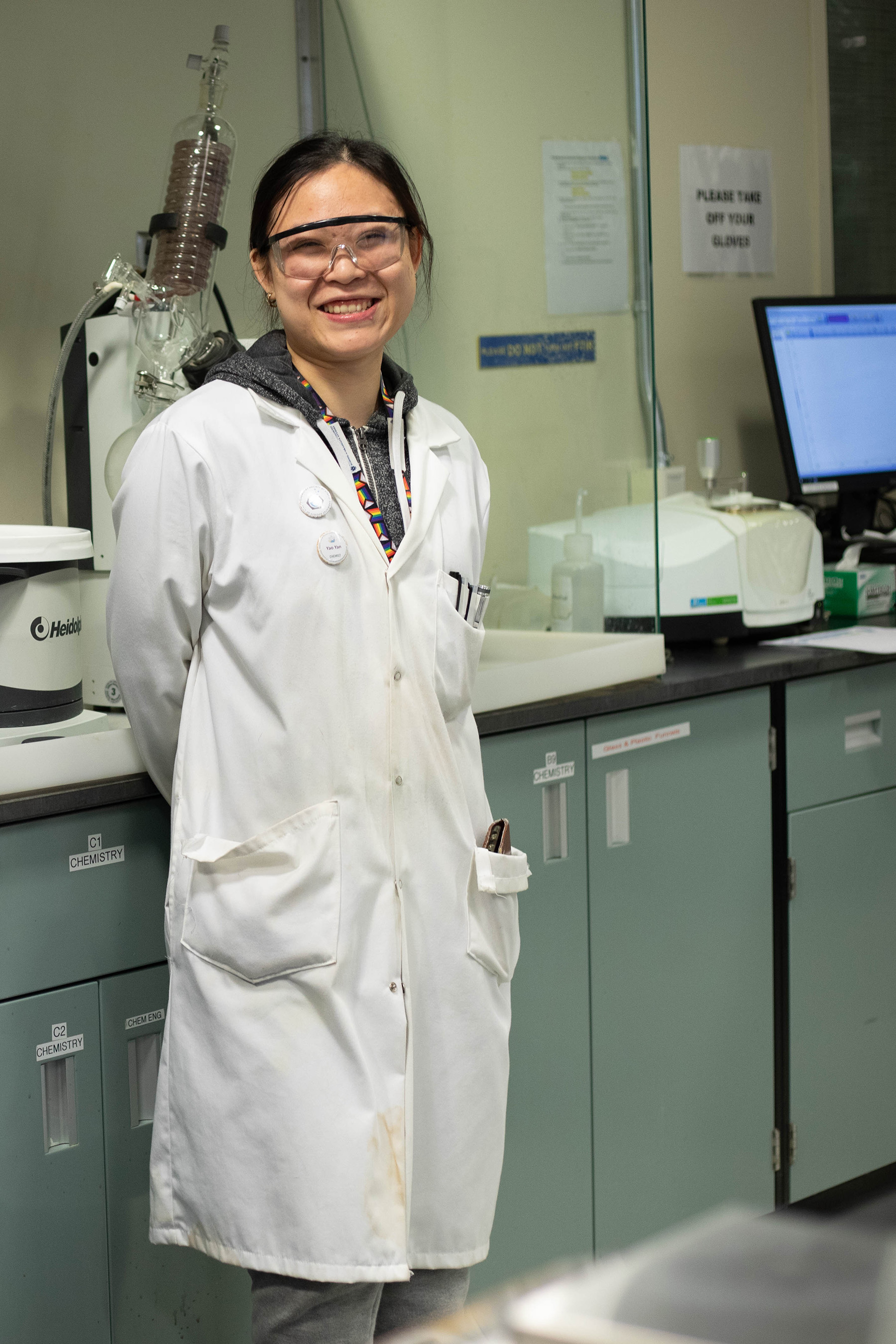 Female chemistry student in PPE, smiling at camera.