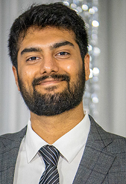 Closeup of a man with South Asian features smiling into the camera.