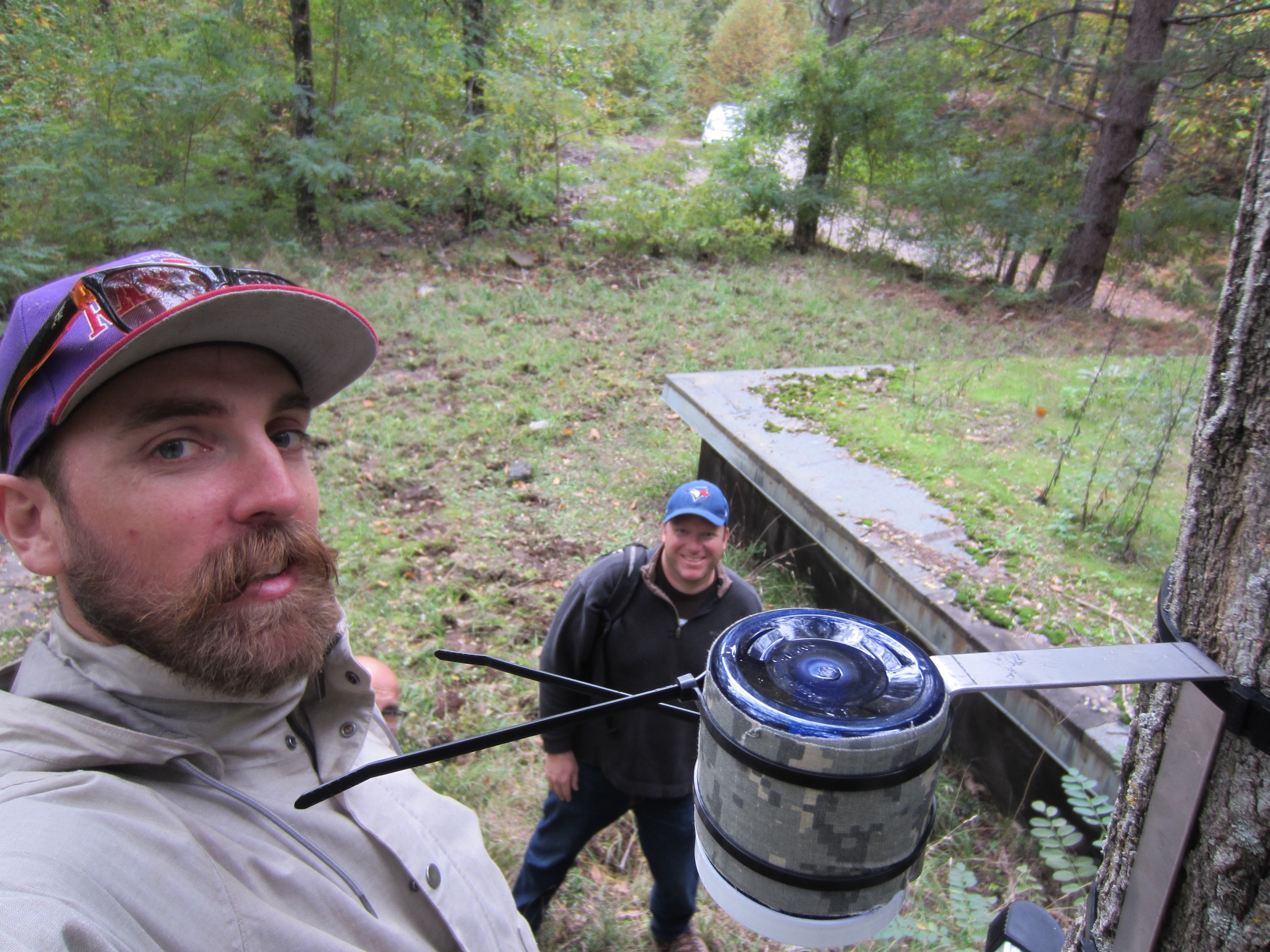 Photo of David McLagan (left) and Carl Mitchell setting up an air sampler in the field. 
